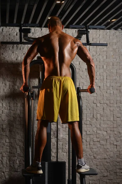 Joven culturista Flexing Espalda Músculos — Foto de Stock