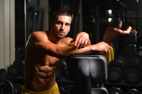 Hombre descansa en el gimnasio después de hacer un entrenamiento — Foto de Stock