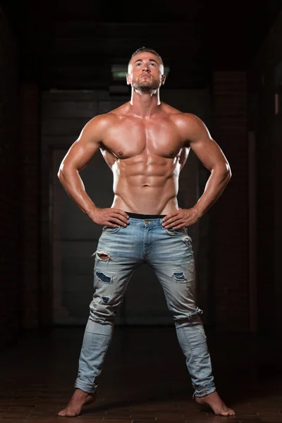 Junger Mann in Jeans lässt Muskeln spielen — Stockfoto