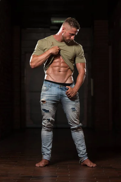 Muskulös Bodybuilder i Jeans flexar muskler — Stockfoto