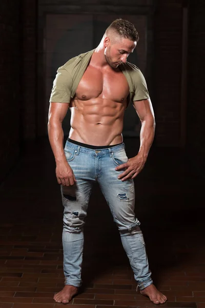 Giovane uomo in jeans muscoli flessibili — Foto Stock