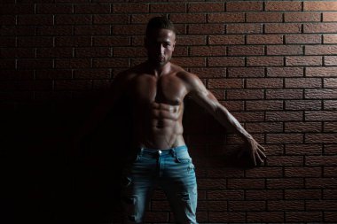 Kasları tuğla duvar üzerinde esneme vücut geliştirmeci