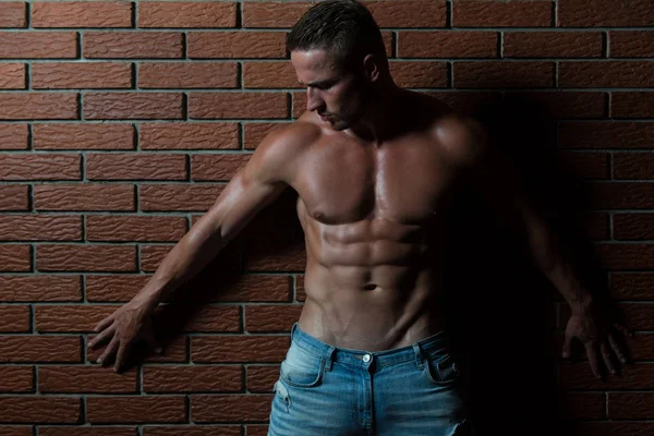 Człowiek muskuły na ściany z cegieł — Zdjęcie stockowe