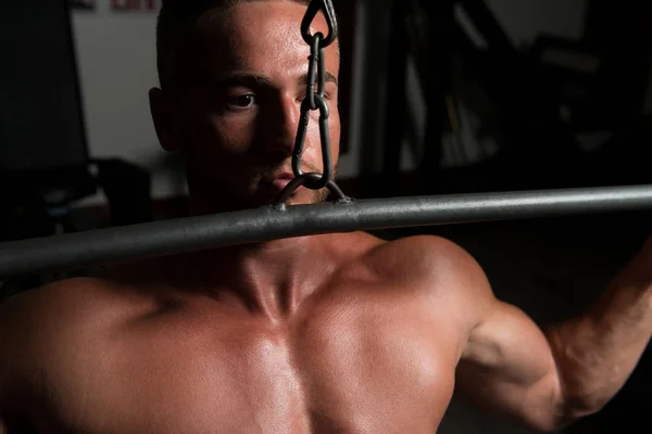 Giovane uomo che esercita di nuovo in palestra — Foto Stock