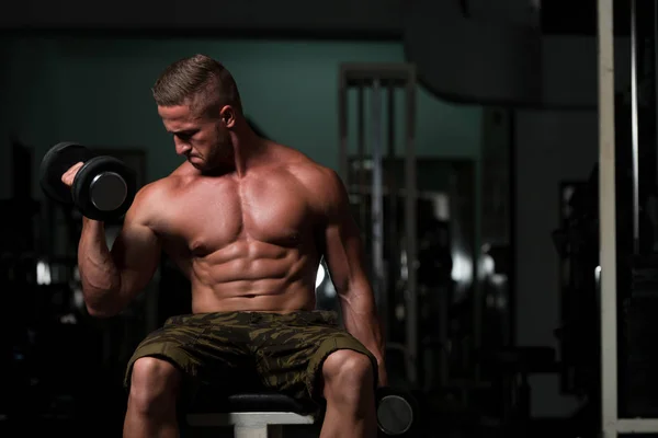 Ejercicio de bíceps con mancuerna en un gimnasio —  Fotos de Stock