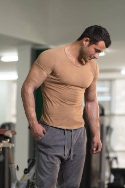 Kahverengi tişört arka plan spor salonunda güçlü adam