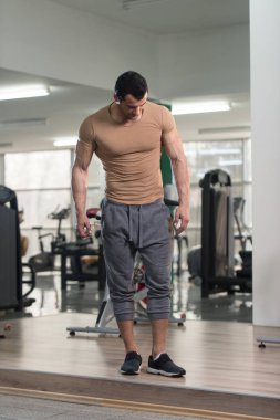 Kahverengi tişört arka plan spor salonunda güçlü adam