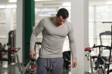 Yeşil T-shirt arka plan spor salonunda güçlü adam