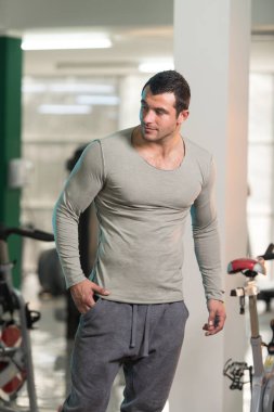 Yeşil T-shirt arka plan spor salonunda güçlü adam