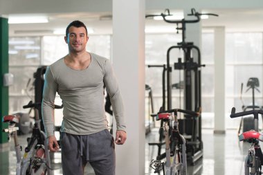 Yeşil T-shirt arka plan spor salonunda güçlü adam