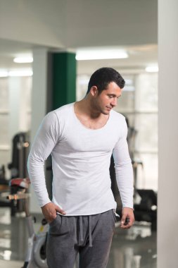 Güçlü adam beyaz tişört arka plan spor salonunda