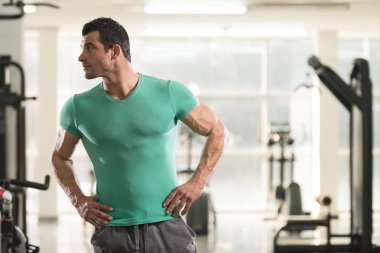 Yeşil T-shirt arka plan spor salonunda güçlü adam