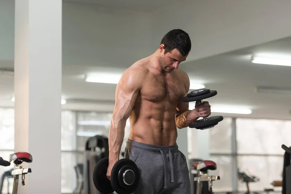 Biceps exercice avec haltère dans une salle de gym — Photo