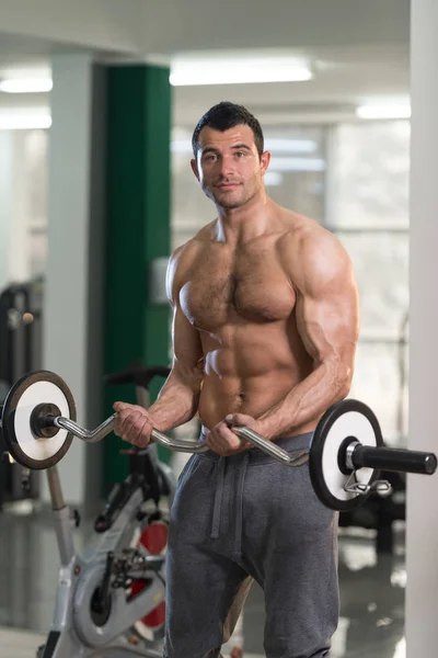 Biceps Exercício com Barbell em um centro de fitness — Fotografia de Stock