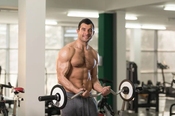 Muscular Man Exercising Biceps With Barbell