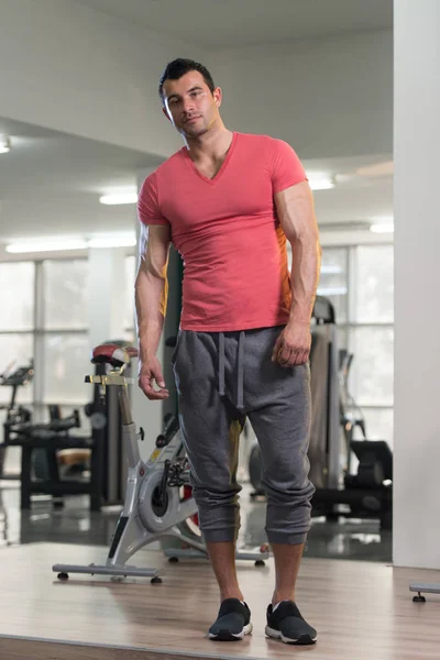 분홍색 티셔츠 배경 체육관에서 강한 남자 — 스톡 사진