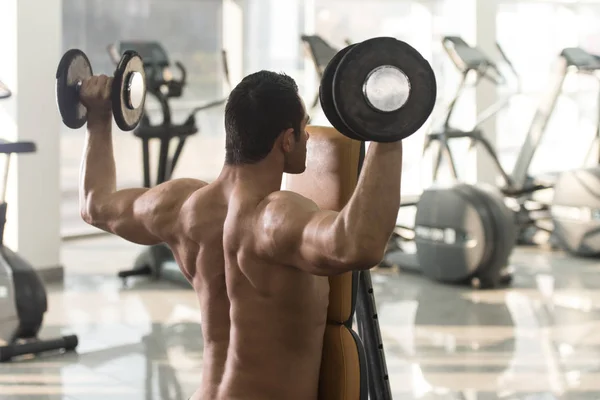 Bir spor salonunda egzersiz Dumbbells ile omuz — Stok fotoğraf