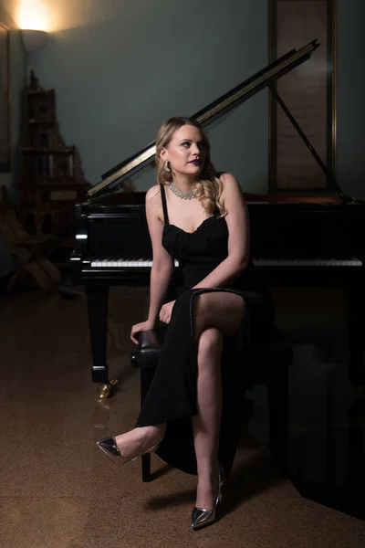 Krásná mladá žena hrající na klavír — Stock fotografie
