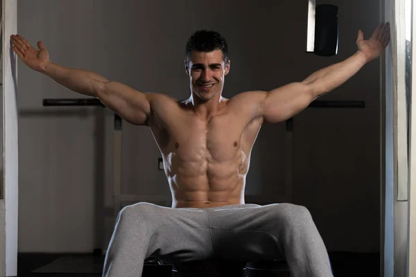 Muscular Man Flexing Muscles In Gym