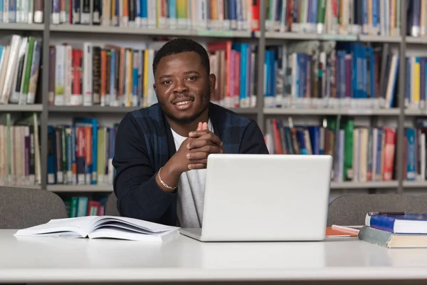 Gelukkig Afrikaanse mannelijke Student met Laptop In bibliotheek — Stockfoto