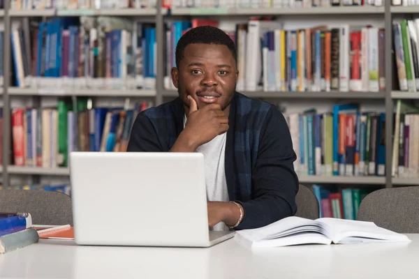 Szczęśliwy Afryki studentowi z laptopa w bibliotece — Zdjęcie stockowe