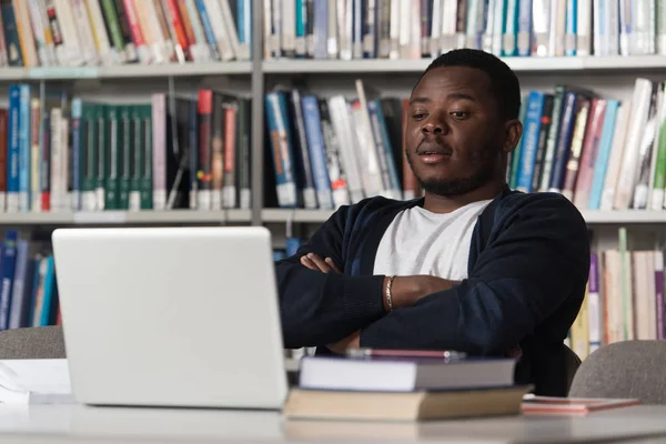 Estudante masculino confuso lendo muitos livros para exame — Fotografia de Stock