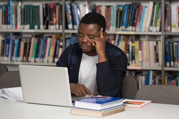 Estudante masculino confuso lendo muitos livros para exame — Fotografia de Stock