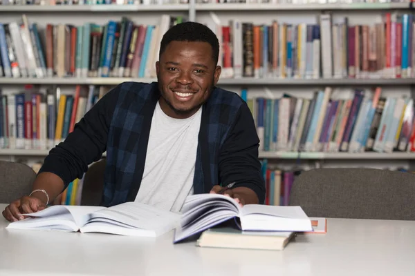 Heureux étudiant africain masculin avec ordinateur portable dans la bibliothèque — Photo