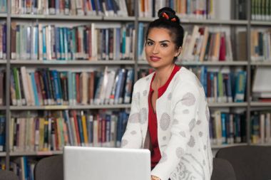 Genç öğrenci onu Laptop kitaplığa kullanarak