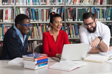 bir kitaplıkta okuyan insanlar