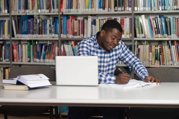 Szczęśliwy Afryki studentowi z laptopa w bibliotece — Zdjęcie stockowe