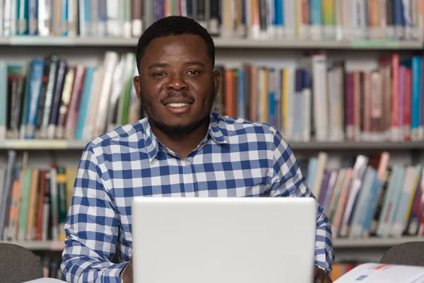 Szczęśliwy Afryki studentowi z laptopa w bibliotece — Zdjęcie stockowe