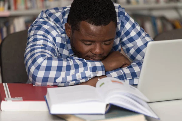 Estudante cansado dormindo na biblioteca — Fotografia de Stock