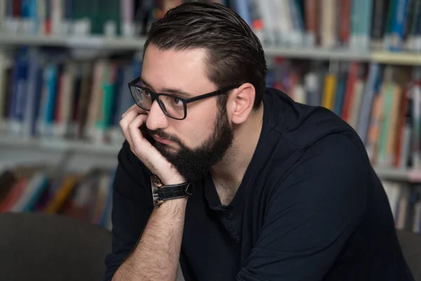 Männlicher Student schläft in Bibliothek — Stockfoto