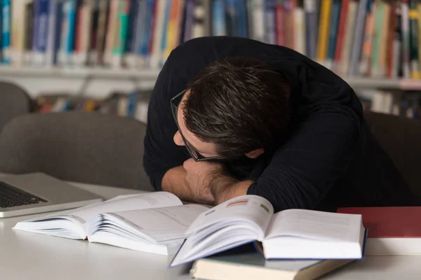 Kaukasische mannelijke Student slapen In bibliotheek — Stockfoto