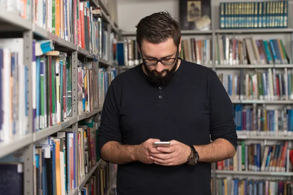 Hübsche männliche Hochschulstudentin tippt auf Handy — Stockfoto