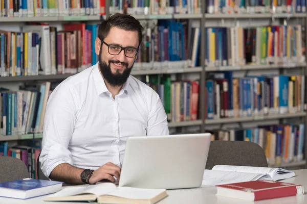 Happy manlig Student med Laptop i biblioteket — Stockfoto