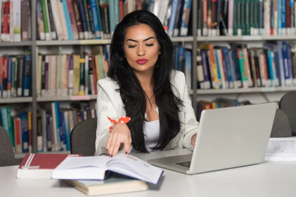 Estudiante feliz trabajando con el ordenador portátil en la biblioteca — Foto de Stock