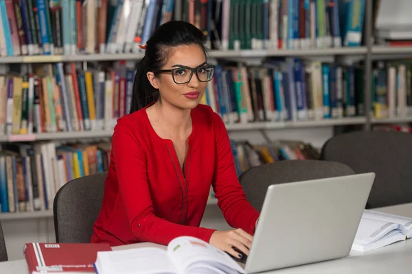 Ung Student med sin Laptop i ett bibliotek — Stockfoto