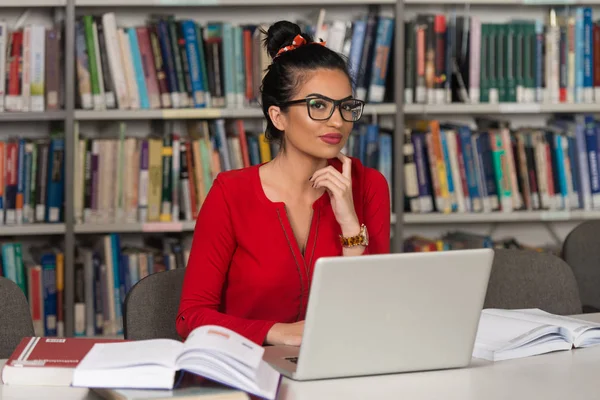 快乐的女学生工作与图书馆的笔记本电脑 — 图库照片