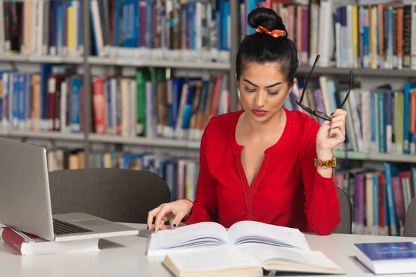 Estudiante feliz con portátil en la biblioteca —  Fotos de Stock
