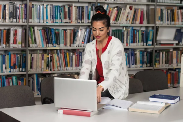 Estudiante feliz trabajando con el ordenador portátil en la biblioteca — Foto de Stock