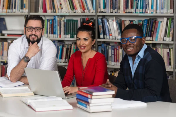 Casal de estudantes em uma biblioteca — Fotografia de Stock