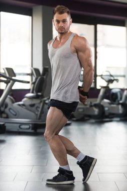 Kaslı erkek fanila içinde jimnastik salonu kas esneme