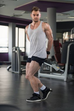 Genç vücut geliştirmeci fanila içinde kasların esneme