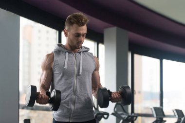 Genç adam için pazı Dumbbells ile egzersiz yaparak