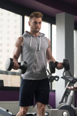 Genç adam için pazı Dumbbells ile egzersiz yaparak