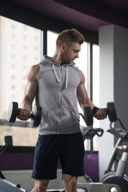Genç adam için pazı Dumbbells ile egzersiz yaparak