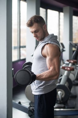 Genç adam için pazı Dumbbells ile egzersiz yaparak