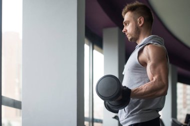 Genç adam için pazı Dumbbells ile egzersiz yaparak